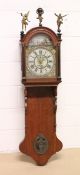 A DUTCH OAK CASED FRIESLAND WALL CLOCK, with embossed metal dial. 4ft. 2 ins high