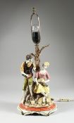 A CONTINENTAL PORCELAIN LAMP, a couple beneath a tree, 1 ft. 5 in. high (a piece missing).