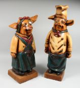 A PAIR OF AMUSING POTTERY PIGS, 24 in. and 21 in. high.
