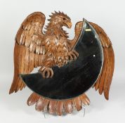 A GOOD CARVED WOOD POSSIBLY BLACK FOREST EAGLE FRAMED CRESCENT MOON SHAPED MIRROR. 22 inches long.