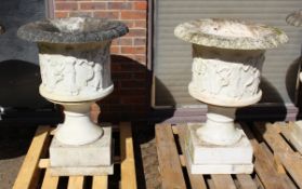 A SUPERB NEAR PAIR OF ITALIAN CARVED WHITE MARBLE URNS ON STANDS, the sides covered with dancing