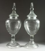 A LARGE PAIR OF CUT GLASS URN, SHAPED VASES AND COVERS, 31 ins. high.
