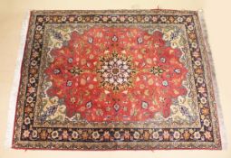 A GOOD SMALL PERSIAN CARPET, red ground with all over floral decoration within a similar blue border