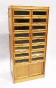 A GOOD HABERDASHERY CABINET with eight pairs of sliding glass drawers with brass handles. The base