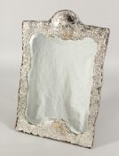 A GOOD SILVER UPRIGHT MIRROR with repousse decoration, flowers, scrolls and figures. London 18ins