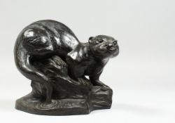 A BRONZED FIGURE OF A OTTER on a rocky base,signed T Wick.