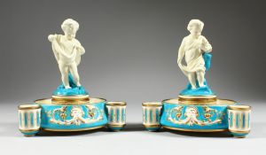 A PAIR OF MINTON PORCELAIN CIRCULAR CENTRE PIECES with young cherubs, 7.5 inches high.
