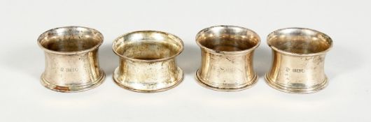 FOUR VARIOUS SILVER SERVIETTE RINGS.