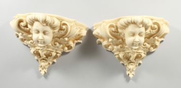 A PAIR OF COMPOSITION WALL POCKETS with mask and scrolls, 1 ft. 2 in. wide.