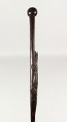 A NATIVE WOODEN WALKING STICK carved with an reptile. 3ft long.