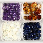 FOUR SMALL BOXES OF CABOCHON STONES