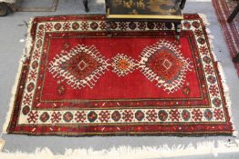 A small Persian red ground rug.