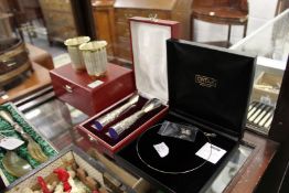 A cased set of two beakers, a similar cased set of two bud vases and a necklace and earring set.