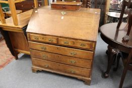 A George III oak bureau, the fitted interior having a small door with old paper label.