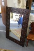 A large mirror with carved wood frame.