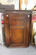 A George III oak hanging corner cupboard.
