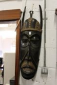 A large carved wood wall mask.