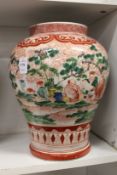 A large Chinese vase decorated with seated figures in a landscape.