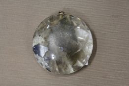 A heavy circular rock crystal pendant.