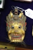 A small Chinese carved and gilded mask.