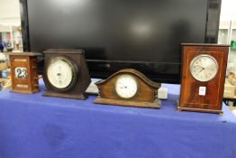 Two mantle clocks, a barometer and a desk calendar.
