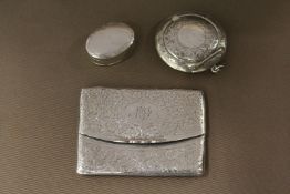 An engraved silver calling card case and two pill boxes.