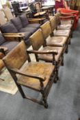 A set of six oak and studded leather dining chairs, two with arms.