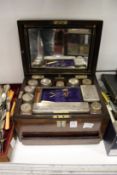 A Victorian walnut dressing table box containing cut glass jars with plated mounts.