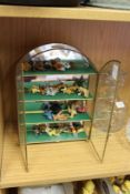 A miniature glass cabinet containing tiny Teddy bears.