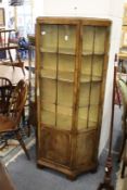 A good walnut display cabinet with central glazed door flanked by angled glazed sides.