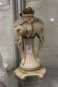 An unusual continental porcelain lamp base modelled as three elephant heads.