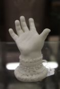 A small bisque porcelain model of a baby's hand.