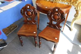A pair of 19th century mahogany hall seats with carved backs.