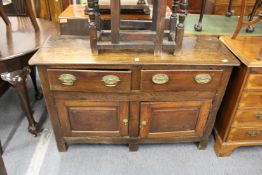 An 18th century small oak dresser with two drawers and two cupboard doors.