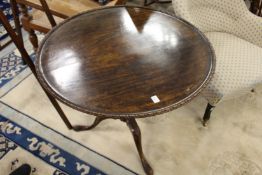 A George III mahogany tilt top tripod table with carved decoration.