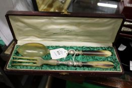 A cased set of horn handled salad servers.
