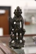 A small cast bronze deity.