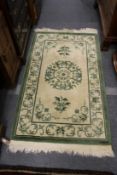 A pale cream and green Chinese rug.