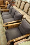 An oak framed Bergere three piece suite comprising three seater settee and a pair of armchairs.