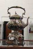 A good plated kettle on stand with embossed decoration, the lid having a Chinese man finial.