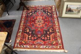 A red ground Persian design small rug.
