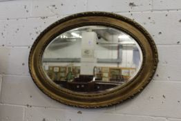 A gilt framed oval wall mirror.