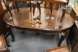 A mahogany extending dining table with one extra leaf on carved cabriole legs with claw and ball