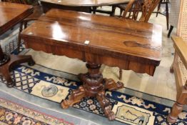 A 19th century rosewood foldover card table on carved column support with four carved legs.