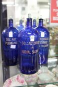 Three large blue glass poison bottles.