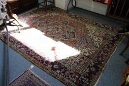 A Persian carpet, beige ground with stylized decoration.