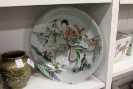 A Chinese Famille Jaune circular dish depicting figures.
