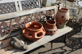 A garden ornament modelled as a cat and three terracotta strawberry pots.