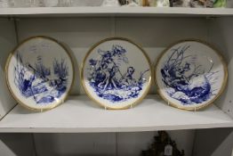 A set of three blue and gilt decorated cabinet plates depicting imps and fairies.