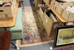 A large beige ground Chinese carpet decorated with flowers, birds and butterflies (some staining).